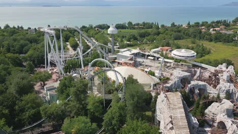 Drone-push-in-over-roller-coaster-tracks-of-Gardaland,-Lake-Garda-Italy