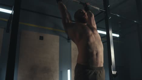hombre realizando pull-ups en un gimnasio