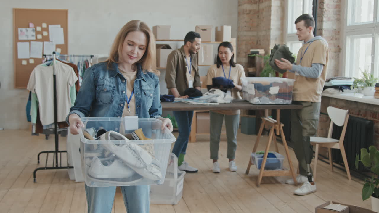 Portrait of Female Volunteer Holding Container with Donated Clothes
