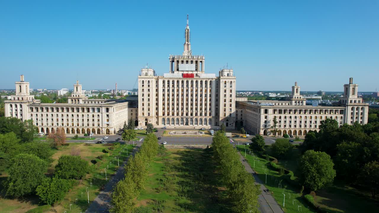 루마니아 부쿠레슈티 에 있는 자유 언론 건물 의 공중 사진, 초록색 식물 에 둘러싸인 곳, 해가 뜨고,  ⁇ 은 파란 하늘