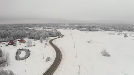 aerial drone view of a winding highway road through a frozen winter landscape with icy trees. frost on the trees after extreme cold.