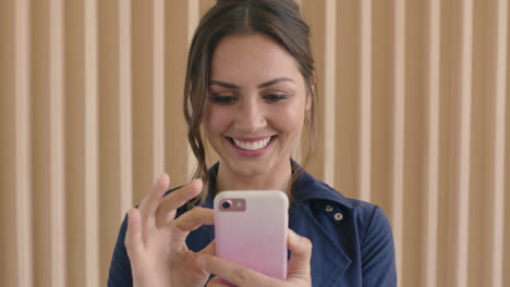 retrato de una hermosa joven mujer morena sonriendo feliz disfrutando de mensajes de texto navegando usando tecnología móvil de teléfono inteligente