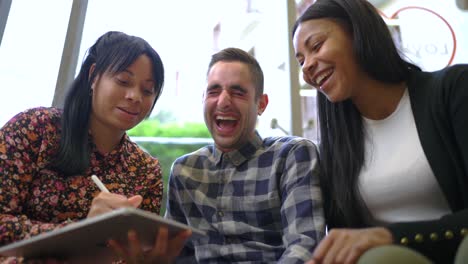 Cheerful-multiethnic-friends-browsing-on-tablet