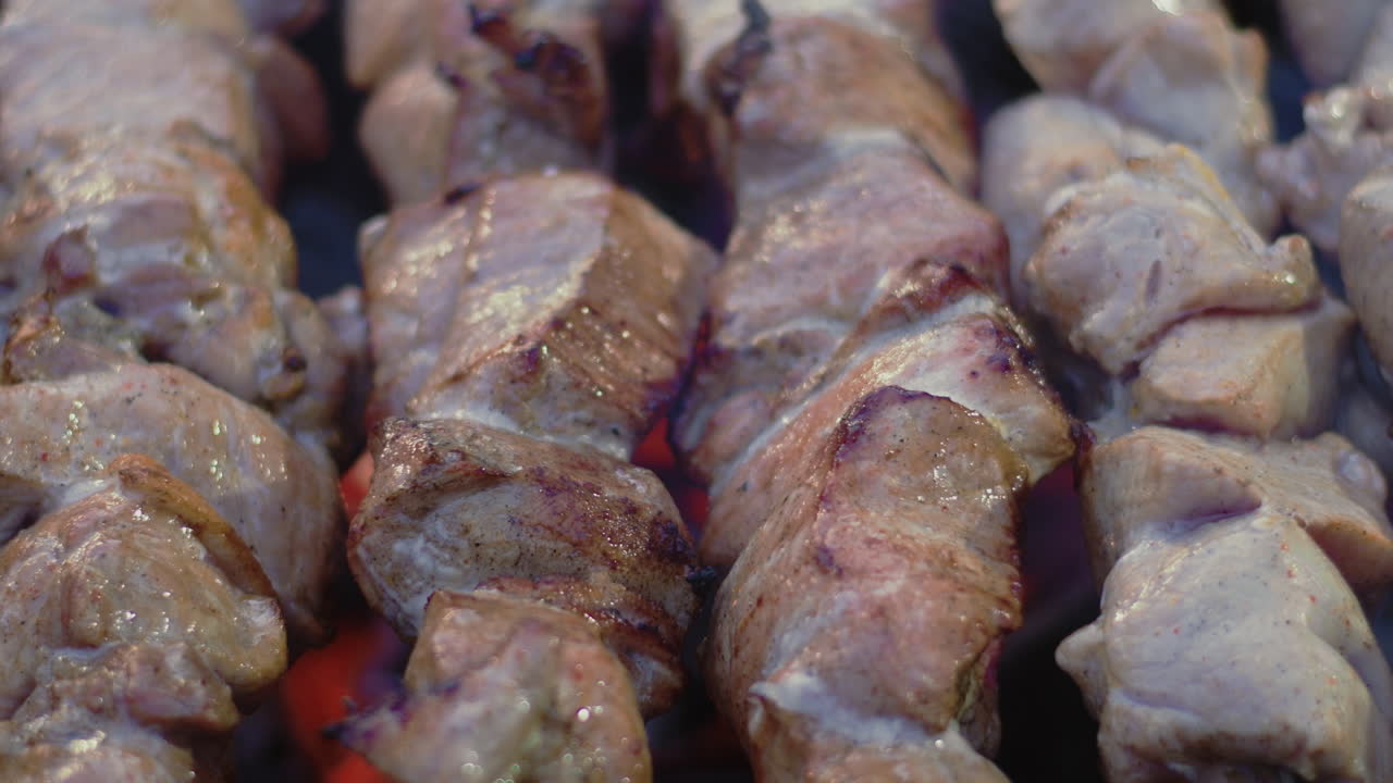 kebabs de cerdo de primer plano asando en pinchos de metal. carne de cerdo a la parrilla para la fiesta