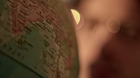 a close-up view of a globe showing the african continent with a person in the blurry background