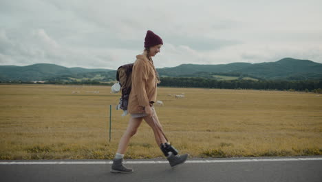 Turista-Con-Mochila-Y-Binoculares-Caminando-Por-La-Carretera