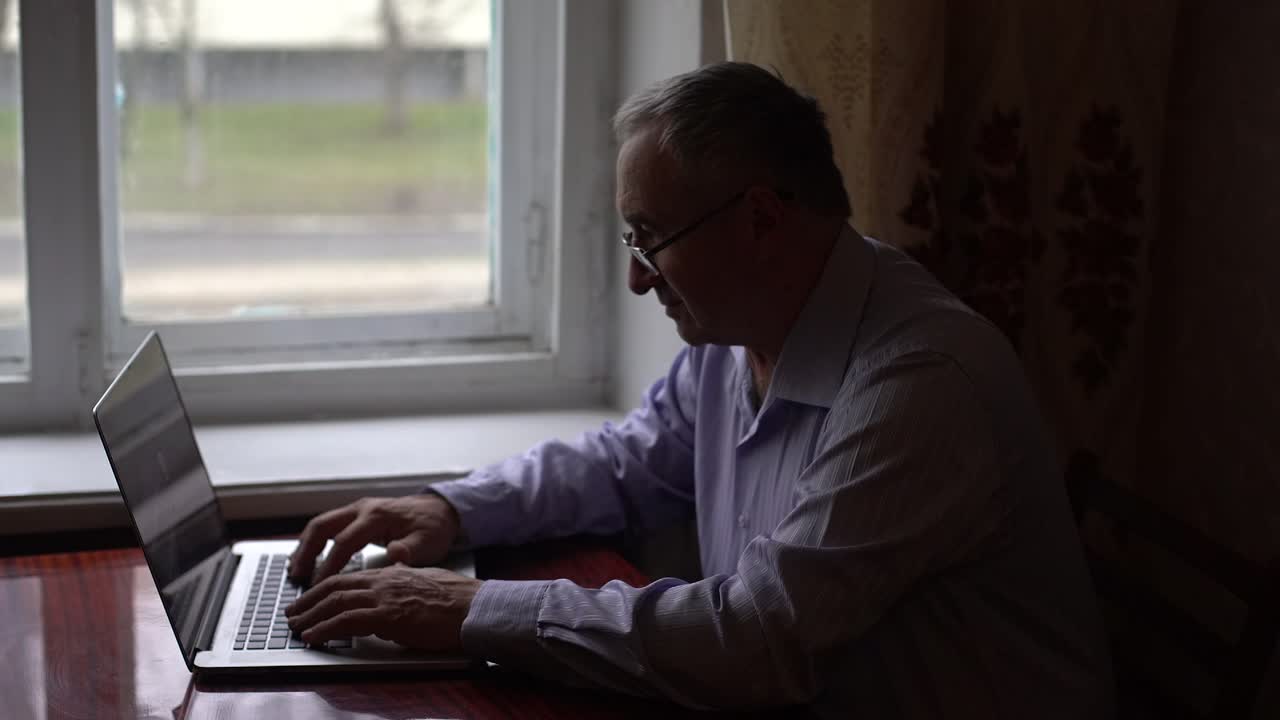 modern medicine, elderly man communicates with doctor online via video communication using laptop while sitting at home at table during quarantine isolation