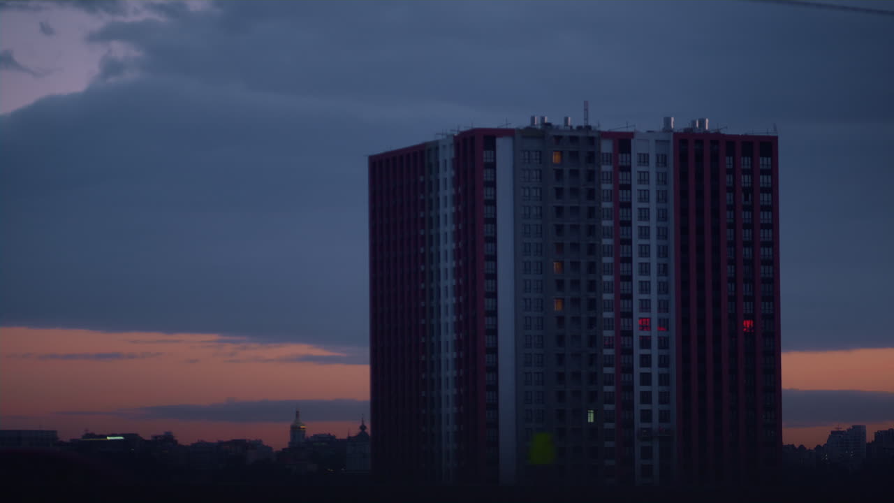 edificio moderno de gran altura al atardecer al atardecer. nubes hinchadas se reúnen sobre la ciudad