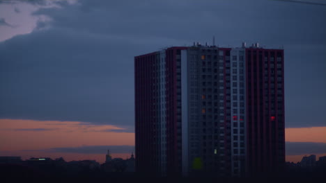 Modernes-Hochhaus-Bei-Sonnenuntergang-In-Der-Abenddämmerung.-Bauschige-Wolken-Ziehen-über-Der-Stadt-Zusammen