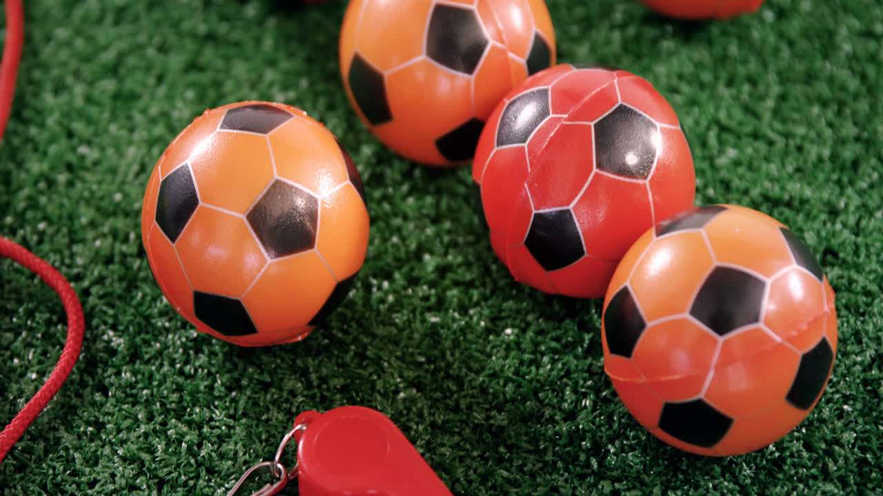 Palloni da calcio e fischietto dell'arbitro su erba sintetica 4k
