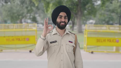 happy sikh indian police man showing okay sign