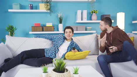 el hermano mayor molesta a su hermano menor que ve la televisión en casa.