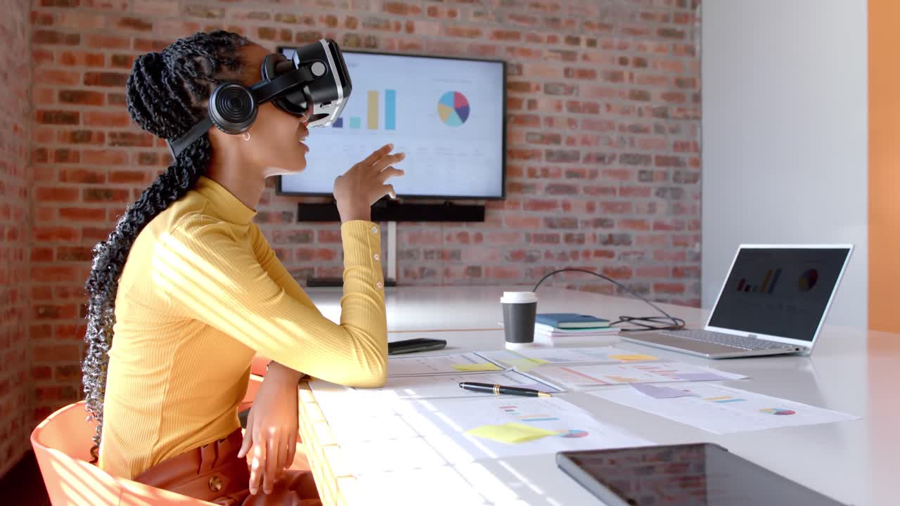 African american casual businesswoman using vr headset in sunny meeting room, slow motion