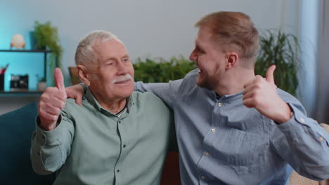 abuelo mayor feliz con el nieto hombre mostrando pulgares hacia arriba, como señal positiva, buenas noticias en casa