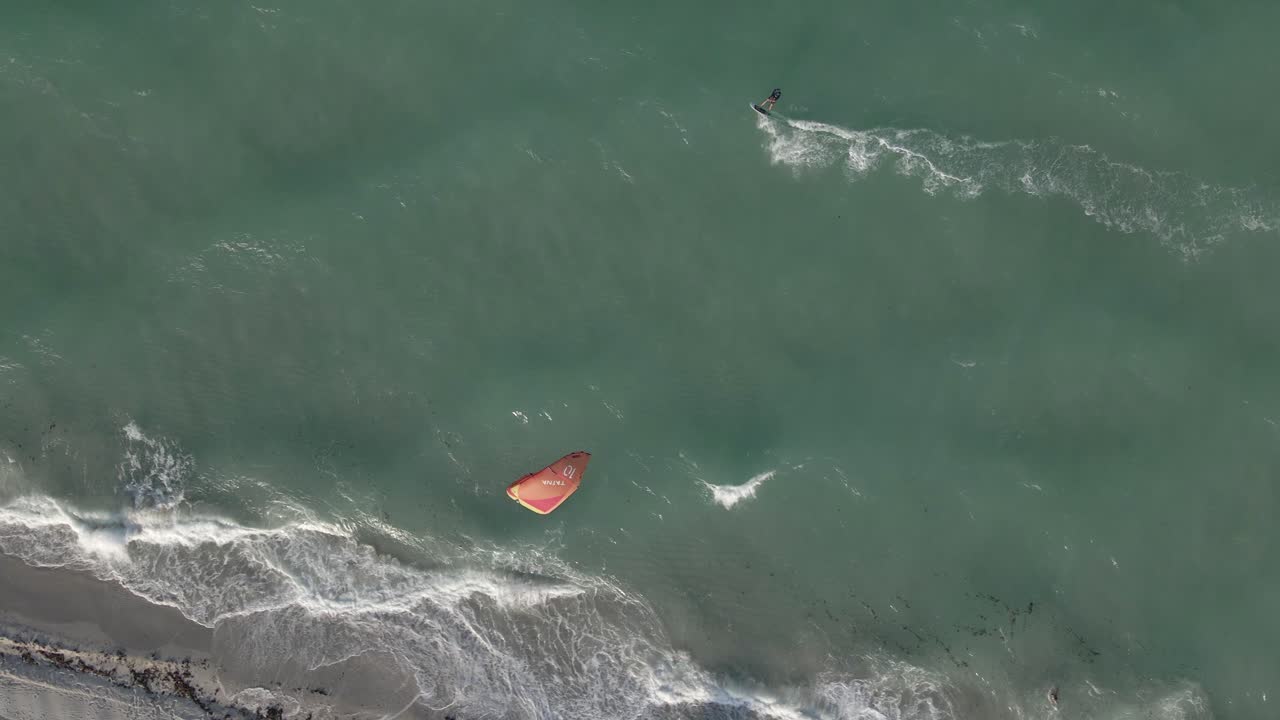 antena alta: playa paralela de kitesurf en un océano verde picado y ventoso