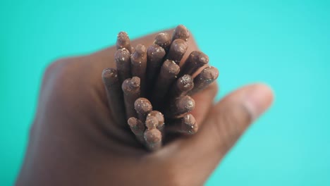 hand holding chocolate covered biscuit sticks