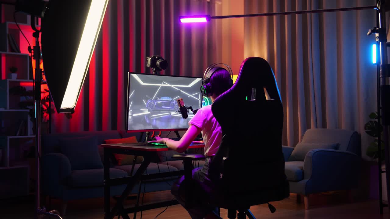 Back View Of Asian Girl Streamer Playing Car Racing Game Over Network On Personal Computer. Challenge And Bully Competitor, Live Stream Video Game, Desk Illuminated By Rgb Led Strip Light