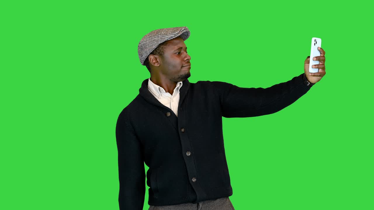 Homem negro bonito com chapéu tirando uma selfie em Tela Verde, Chroma Key.