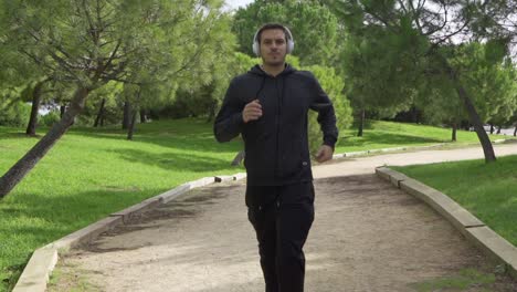 man running to the camera with sneakers and white headphones