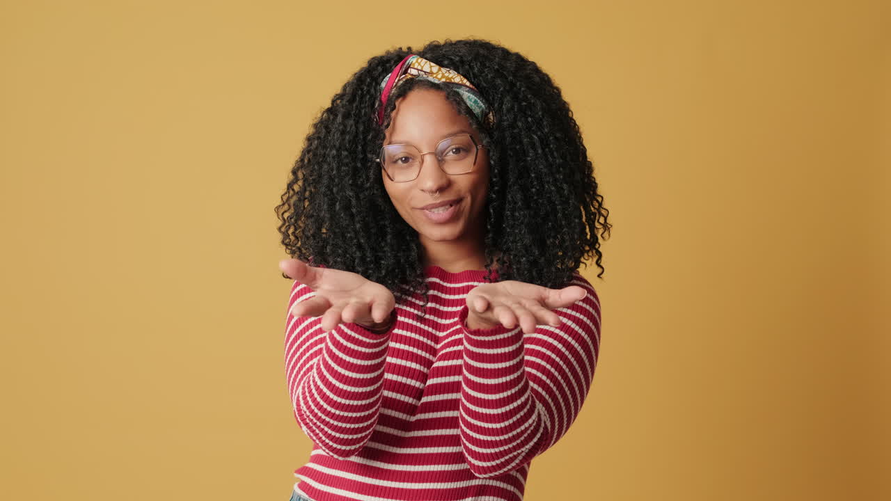 Happy Young African American Woman Blowing a Kiss and Smiling
