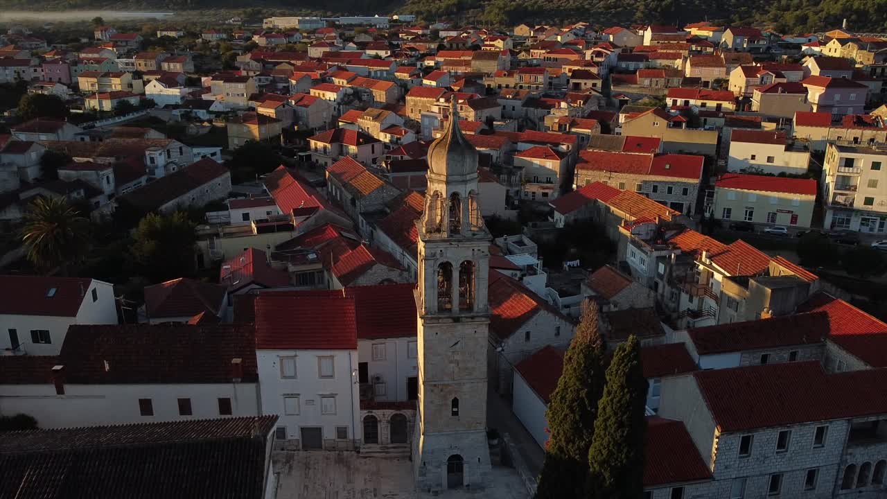 Spettacolari riprese drone di un drone che gira attorno al campanile di una chiesa medievale su un'isola della Croazia.