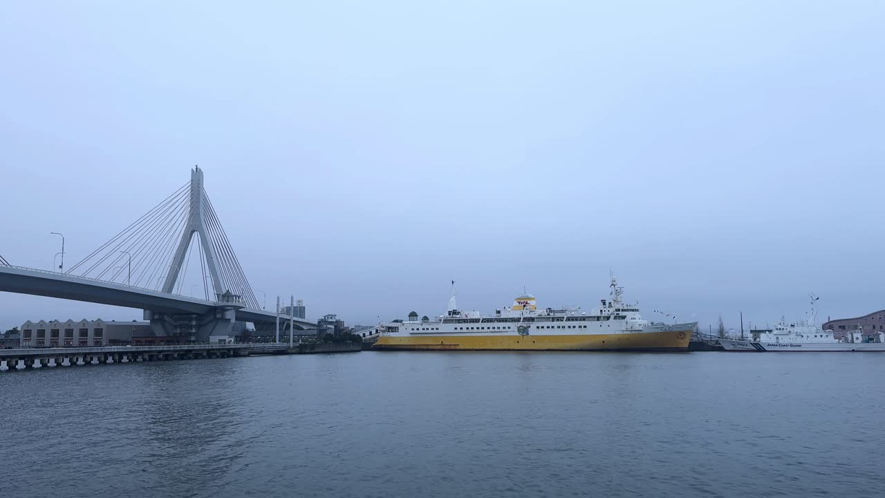 Morning view of Aomori Bay with a yellow ferry, calm waters, and a cable-stayed bridge