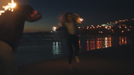 Mejores-Amigos-Bailando-Con-Bengalas-En-La-Playa-Por-La-Noche-Chicas-Adolescentes-Celebrando-La-Víspera-De-Año-Nuevo-Divirtiéndose-Bailando-Con-Fuegos-Artificiales-De-Bengala-Junto-Al-Mar