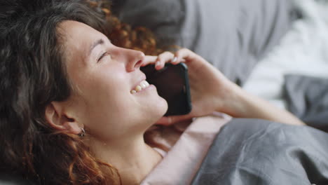 woman on phone in bed