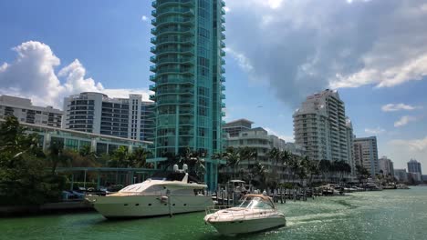 moving shot going through the waterways of miami with nice homes and high rises and yachts