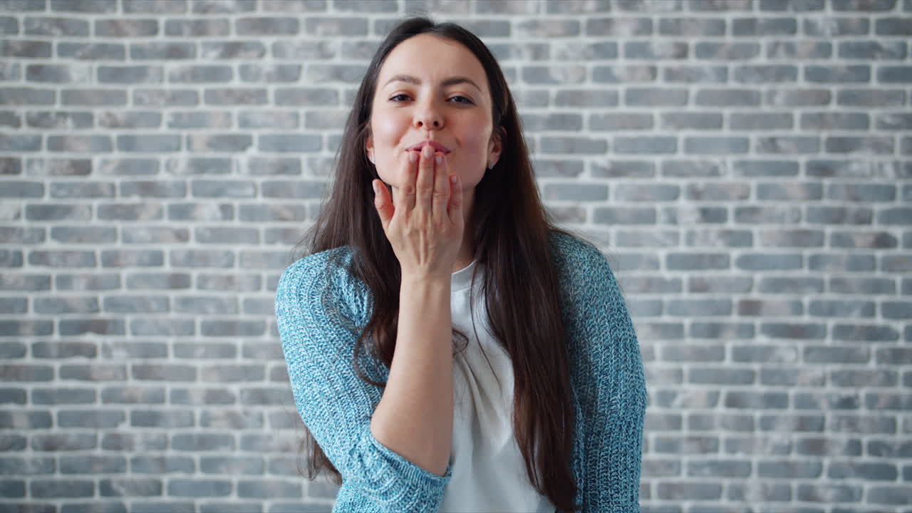 Woman with a happy expression in front of a brick wall