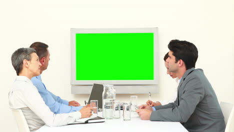 Business-team-looking-at-white-screen-and-talking