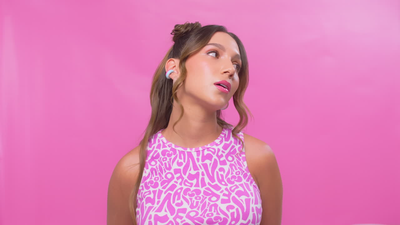 Woman moving across the frame in slow motion with glossy pink makeup and soft curls