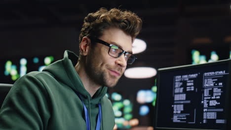smiling analyst typing keyboard desktop computer in data center room closeup