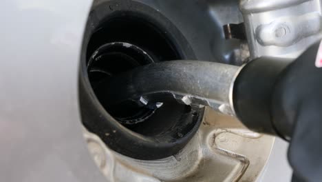 close-up of a fuel nozzle being inserted into a vehicle's gas tank