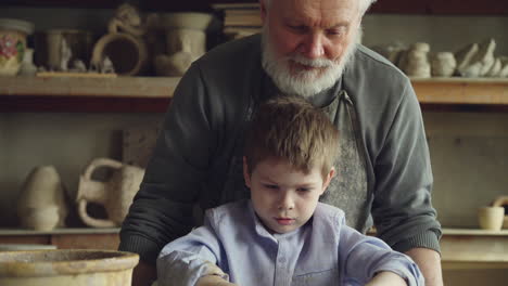 grandfather and grandchild learning pottery together