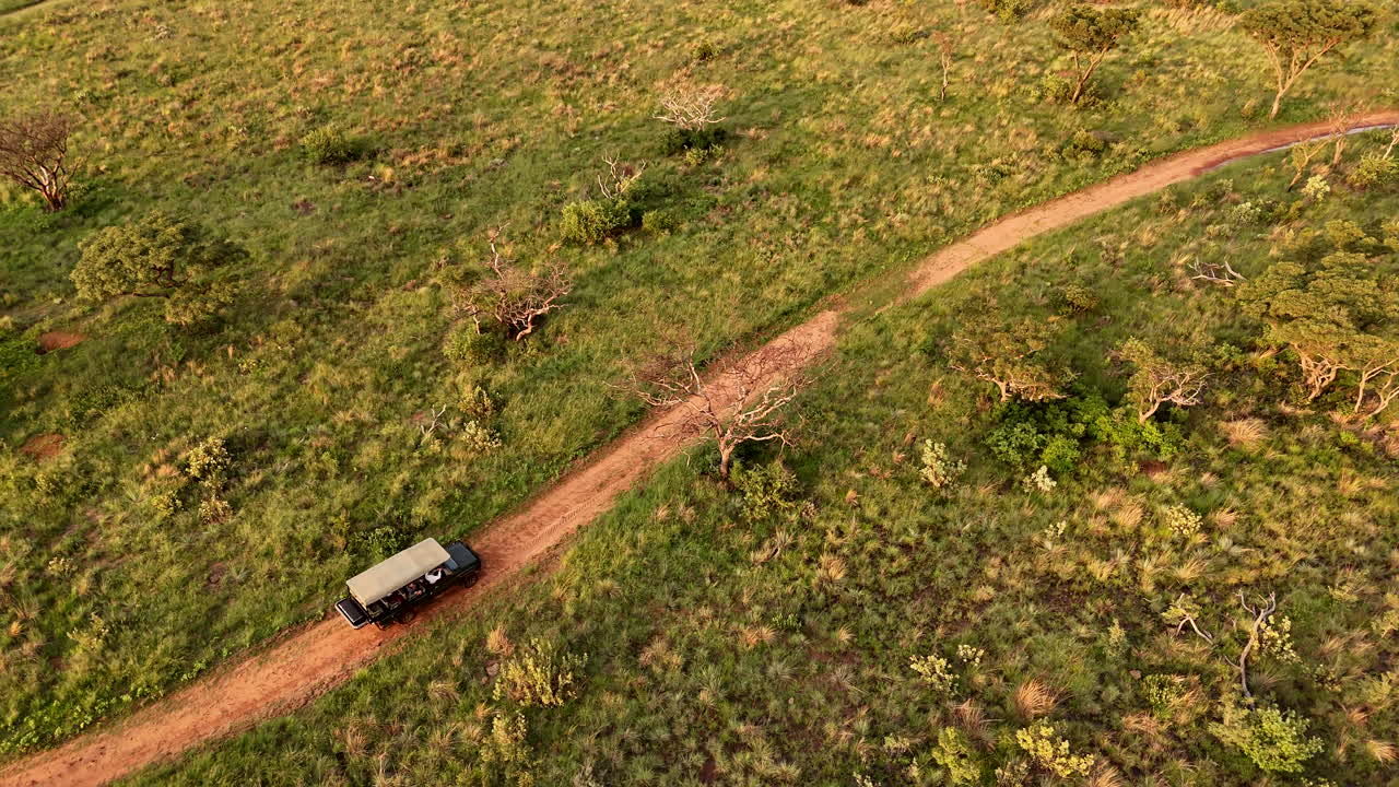 Veicolo safari 4x4 durante un safari fotografico su strada sterrata in Africa, con monitoraggio aereo