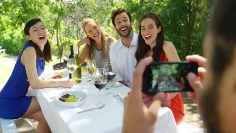 hombre tomando una foto de sus amigos con un teléfono móvil