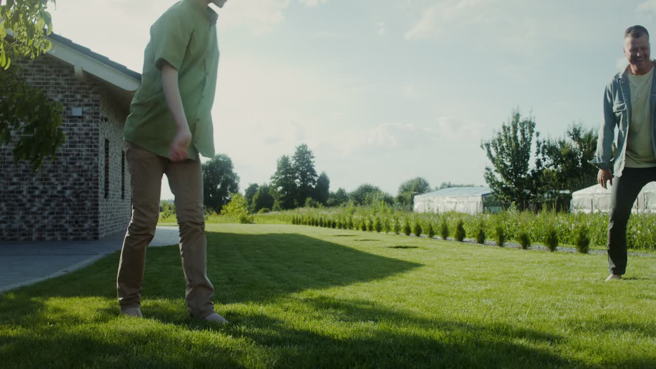 아버지 와 아들 이 뒷마당 에서 축구 를 하고 있다