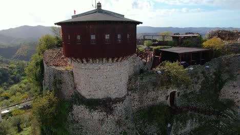 petrela castle tower: aerial circle drone shot captures the majestic structure standing atop a rocky hill in stunning panoramic views