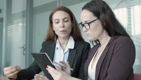 confident brunette businesswomen carrying out survey with tablet