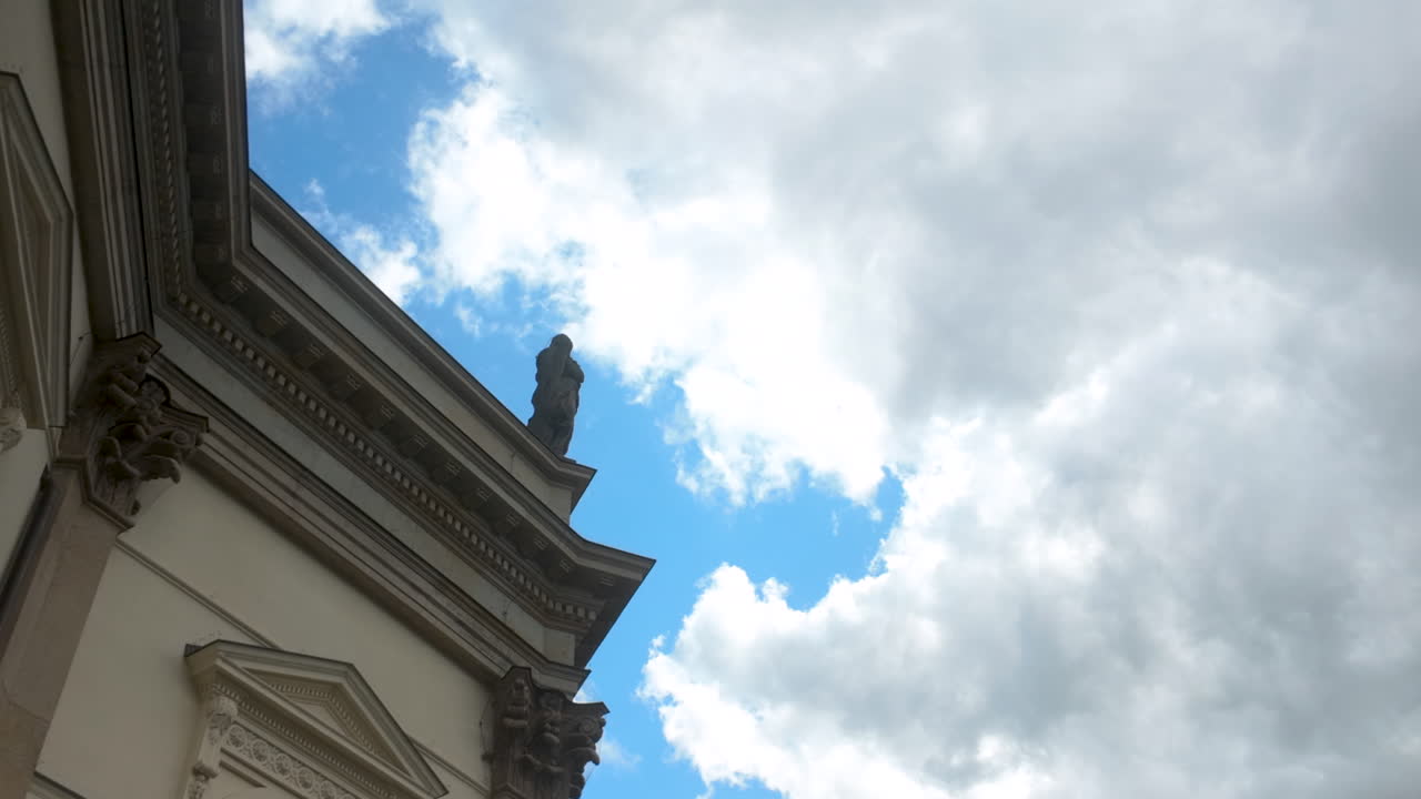 Low-angle view of a historic Berlin building with classic architectural details against a cloudy sky