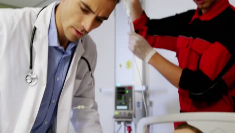 doctor and paramedic examining a patient in emergency room