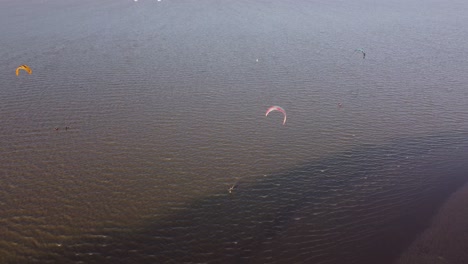 Aerial-orbit-shot-of-Kite-surfers-surfing-on-Rio-de-la-Plata-River-near-Vicente-Lopez-during-sunny-day