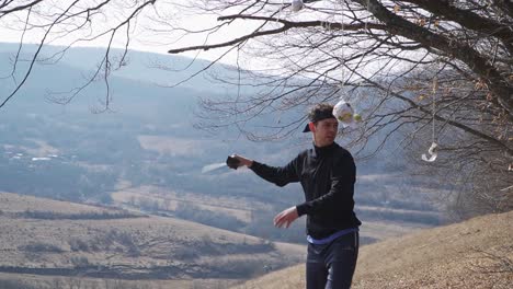 a skilled martial artist practices with his katana on a scenic hillside, striking targets hanging from tree branches. dynamic, precise, and captivating for martial arts enthusiasts.