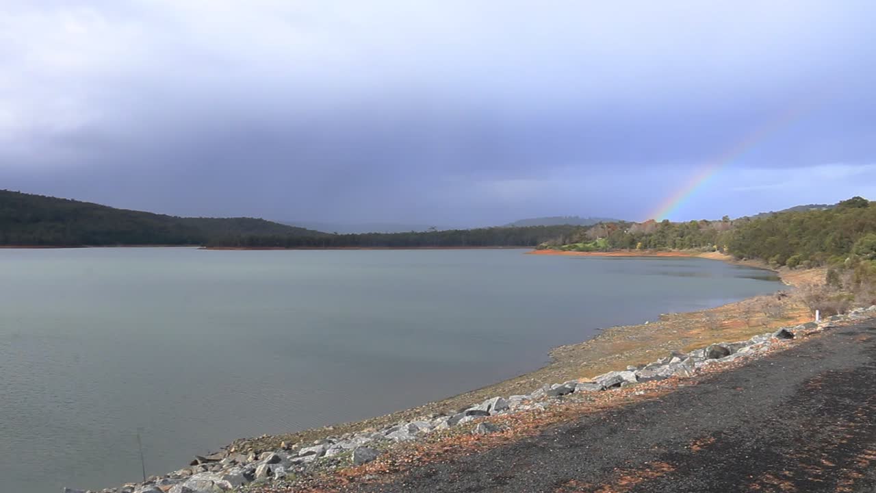 día lluvioso con vistas al embalse, panorámica a la derecha para revelar el arco iris
