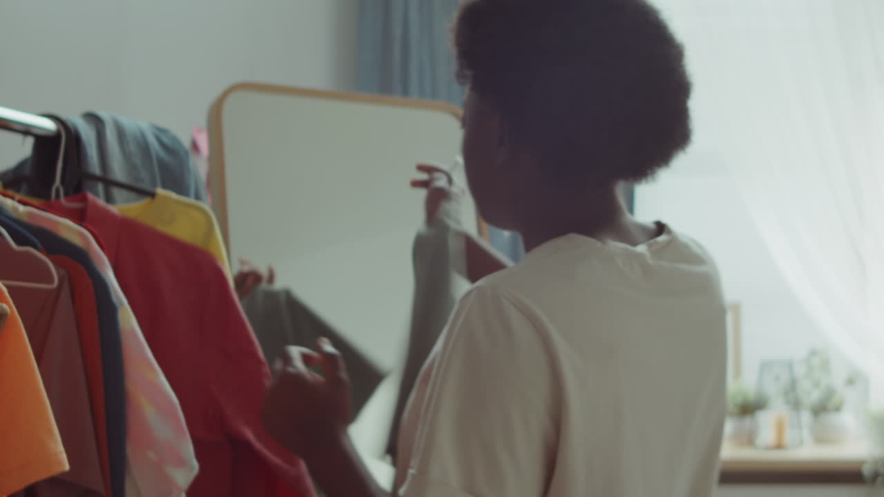 Femme afro-américaine choisissant une tenue à la maison