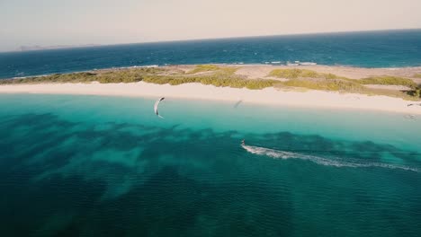 Hombre-Montando-Kitesurf-Y-Deslizándose-Por-El-Agua-Mientras-Sostiene-Una-Cometa-Impulsada-Por-El-Viento,-Los-Roques