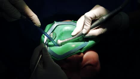 doctor using dental handpiece while treating tooth with caries