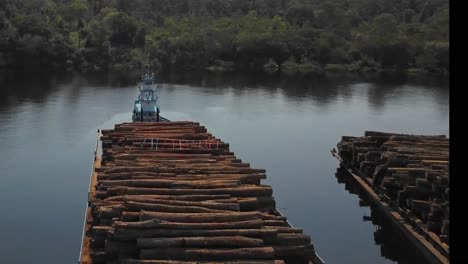 deforestation of the amazon rainforest: logs stacked on barges for shipping down the tocantins river - aerial flyover