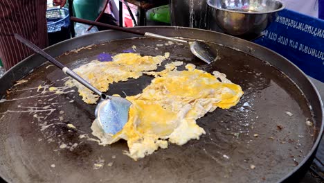 cooking scrambled eggs on a hot griddle.